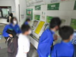 券売機で切符を購入する生徒の画像