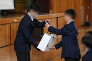 入会にあたって、1年生に記念品として生徒手帳、清掃で使う手ぬぐいが贈られました。