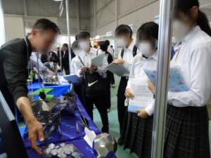 精密加工の説明を真剣に聴く生徒たち