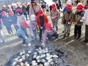 焼けた芋を取る子ども