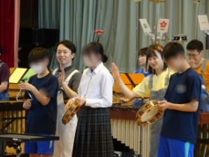 音楽劇「新桃太郎」で、3年生の代表が楽器の使い方を教わりながら一緒に演奏しました。