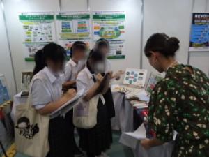 企業の方の説明を真剣に聞いてメモを取る様子の生徒達