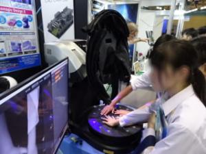 3Ｄスキャンの装置に手を入れて画像を作ってもらっている様子