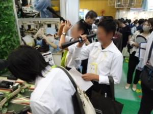 説明を聞きながら、実際にレンズの見え方を試してみる生徒達